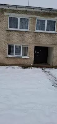 a brick house with a garage in the snow at Pas Dianą 1 aukštas in Jurbarkas
