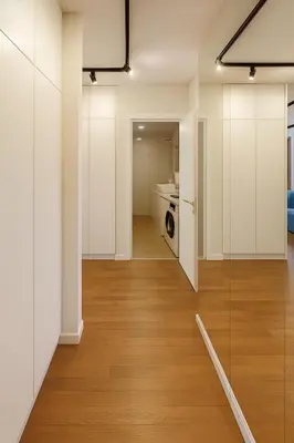 a kitchen with white cabinets and a wooden floor at Self Check-in Home in Vilnius center in Vilnius