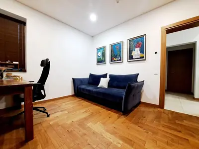 a living room with a blue couch and a desk at White house in Vilnius in Vilnius