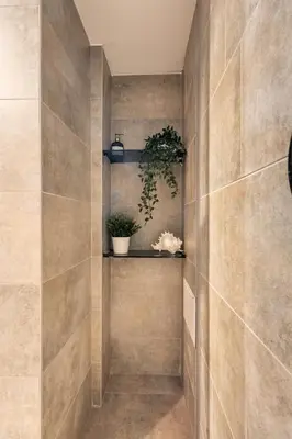 a tiled hallway with a shelf and potted plants at SoHo Gallery Loft 437 in Kaunas
