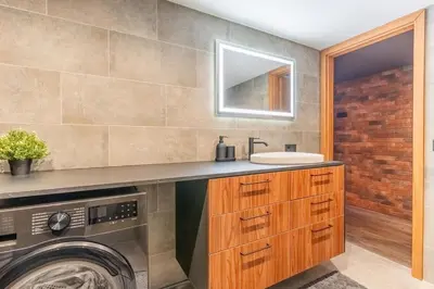 a bathroom with a sink and a washing machine at SoHo Gallery Loft 437 in Kaunas