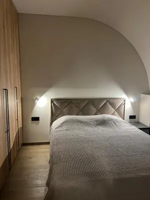 a bedroom with a large bed with an arch above it at Laisves alejos Apartments in Kaunas