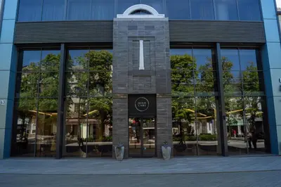 a glass building with a sign in front of it at Laisves alejos Apartments in Kaunas