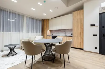 a living room with a table and chairs and a couch at Laisves alejos Apartments in Kaunas