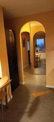 a hallway with an archway and a dining room at Ruola in Kaunas