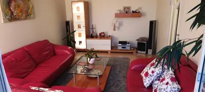 a living room with a red couch and a table at Ruola in Kaunas