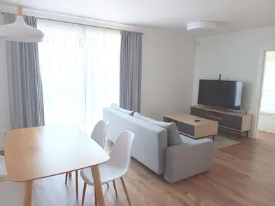 a living room with a couch and a table and a tv at NewTown Krėvos Apartments in Kaunas