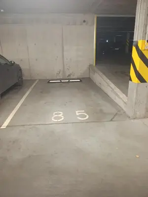 a parking garage with a bike painted on the floor at NewTown Krėvos Apartments in Kaunas