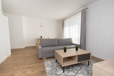 a living room with a couch and a table at NewTown Krėvos Apartments in Kaunas