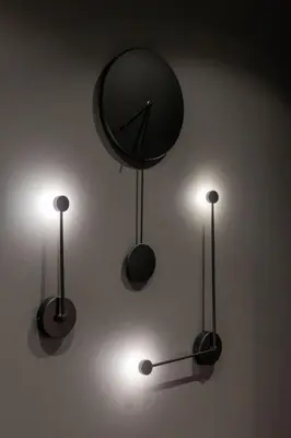 three lights on a wall with a clock on it at Vincent City Luxe - Near Clinic, Arena and Stadium in Kaunas