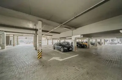 an empty parking garage with two cars parked in it at Vincent City Luxe - Near Clinic, Arena and Stadium in Kaunas
