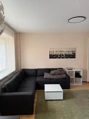 a living room with a black couch and a table at Paupys Cozy Studio in Vilnius