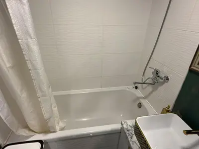 a bathroom with a white tub and a sink at Welcome to Dovas Home in Anykščiai