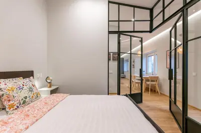 a bedroom with a large bed and a dining room at Nordic Apartment in Kaunas Old Town Area and Balcony in Kaunas