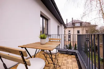 a balcony with a wooden table and chairs at Nordic Apartment in Kaunas Old Town Area and Balcony in Kaunas