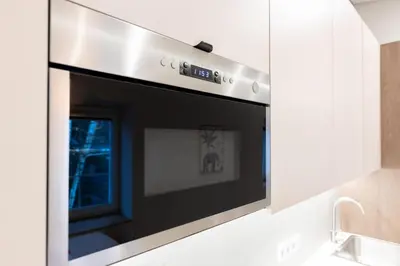 a kitchen with a black oven in a white kitchen at Nordic Apartment in Kaunas Old Town Area and Balcony in Kaunas
