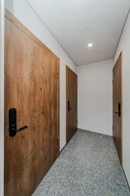 an empty room with wooden doors and a corridor at Chamber House in Kaunas