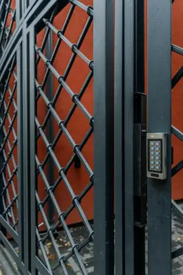 a metal fence in front of a red wall at Chamber House in Kaunas