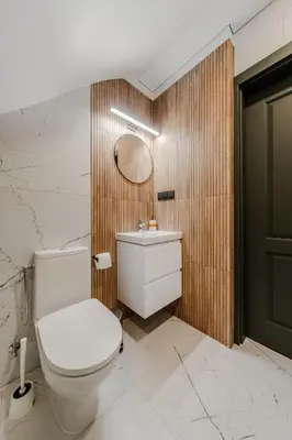 a bathroom with a white toilet and a mirror at Chamber House in Kaunas