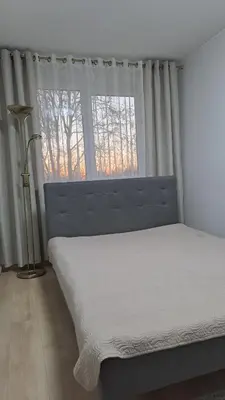 a bedroom with a bed and a large window at Irenos Nuoma in Šiauliai
