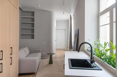 a kitchen with a sink and a couch in a room at Orbis Old Town Suites in Vilnius
