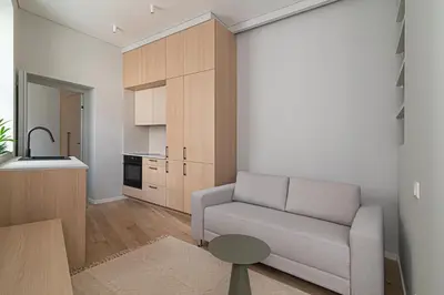 a living room with a couch and a kitchen at Orbis Old Town Suites in Vilnius