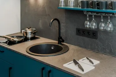 a kitchen counter with a sink and a stove at Chamber Luxury House in Kaunas