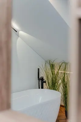 a white bowl sitting on a table next to a plant at Chamber Luxury House in Kaunas