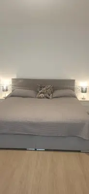 a bedroom with a large bed with two lamps at Vilniaus alėja 4 in Druskininkai