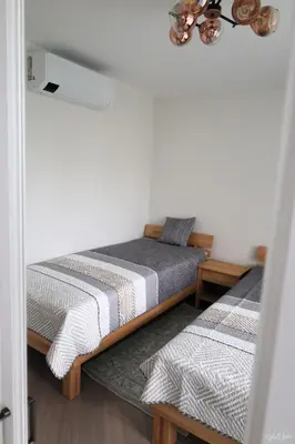 a bedroom with two beds and a mirror at Apartamentai Šiaulių miesto centre in Šiauliai