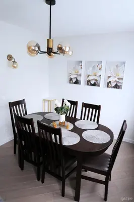 a black dining room table with chairs and a chandelier at Apartamentai Šiaulių miesto centre in Šiauliai