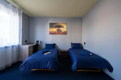 a bedroom with two beds with blue comforters at Julias's House in Šiauliai