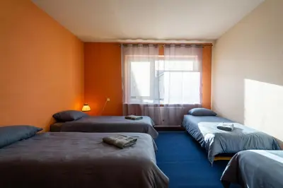 a room with three beds and a window at Julias's House in Šiauliai