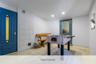 a room with a table football in front of a blue door at Private Lake Escape- 6BR, Sauna & Bonfire in Skersabaliai