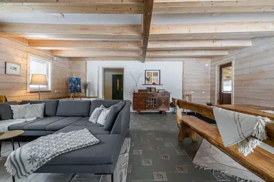 a living room with a couch and a table at Private Lake Escape- 6BR, Sauna & Bonfire in Skersabaliai