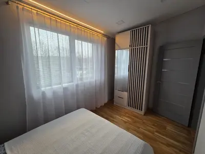 a bedroom with a bed and a large window at Jaukus butas Panemunėje su vaizdu į Nemuną in Kaunas