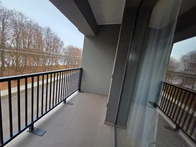 a balcony with a large window with a view of trees at Jaukus butas Panemunėje su vaizdu į Nemuną in Kaunas