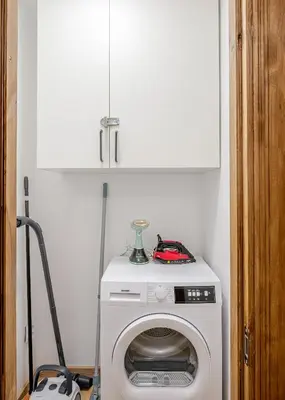 a white washer and dryer in a room at Cozy airport apartment