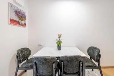 a dining room with a white table and chairs at Cozy airport apartment