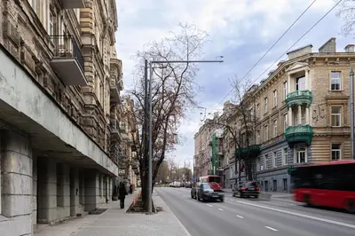 a city street with buildings and cars on the road at Cozy Apartment for Rest & Creativity 6 in Vilnius