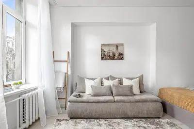 a white bedroom with a bed and a window at Šopeno Butas Cozy Quiet and Well-Located 5 in Vilnius