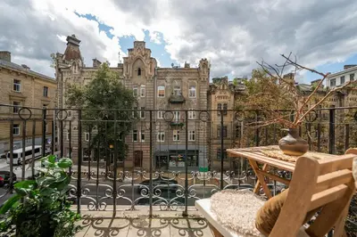 a balcony with a table and a large building at Šopeno Butas Cozy Quiet and Well-Located 5 in Vilnius