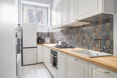 a kitchen with white cabinets and a white sink at Newly Refurbished Luxurious 2 Bedroom Apartment by Reside Baltic in Vilnius