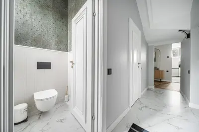 a white bathroom with a toilet and a hallway at Newly Refurbished Luxurious 2 Bedroom Apartment by Reside Baltic in Vilnius