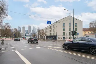 a street with cars driving down a street with a building at Newly Refurbished Luxurious 2 Bedroom Apartment by Reside Baltic in Vilnius