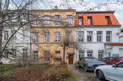 an old building with cars parked in front of it at Newly Refurbished Luxurious 2 Bedroom Apartment by Reside Baltic in Vilnius