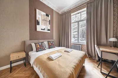 a bedroom with a bed and a desk and a window at Newly Refurbished Luxurious 2 Bedroom Apartment by Reside Baltic in Vilnius