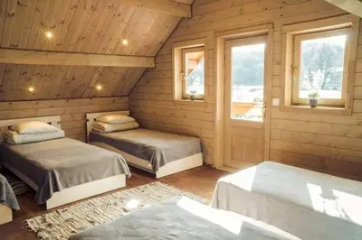 a bedroom with two beds and two windows at Pas Rimute in Zapyškis