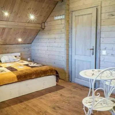 a bedroom with a bed and a table and a door at Pas Rimute in Zapyškis