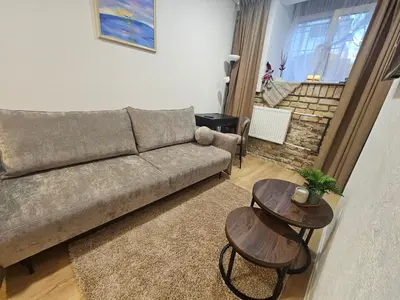 a living room with a couch and two tables at Urban oasis apartments in Vilnius